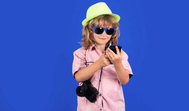 Çocuk gezgin. Telefonla haritaya bakan çocuk. Gezgin turist çocuk, 7-8 yaşında. Cep telefonu olan çocuk.