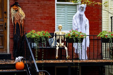 Cadılar Bayramı evi dekorasyonları iskelet, balkabağı ve hayaletler Cadılar Bayramı evinin verandasında. Cadılar Bayramı balkabağı ve dekore edilmiş ev için iskelet. Bir evin Cadılar Bayramı Bahçesi, Şeker mi şaka mı?