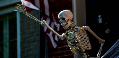 Cadılar Bayramı süslemeleri. Amerikan evi için Cadılar Bayramı balkabağı ve iskeleti. Bir Amerikan evinin ön bahçesinde dekore edilmiş korkunç bir şey. Şeker mi şaka mı? Amerika 'da Cadılar Bayramı. Amerika 'da Cadılar Bayramı