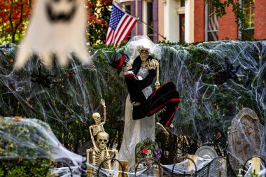 Cadılar Bayramı süslemeleri. Amerikan evi için Cadılar Bayramı balkabağı ve iskeleti. Bir Amerikan evinin ön bahçesinde dekore edilmiş korkunç bir şey. Şeker mi şaka mı? Amerika 'da Cadılar Bayramı. Amerika 'da Cadılar Bayramı