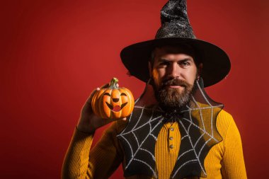 Cadılar Bayramı balkabaklı komik bir model. Cadılar Bayramı şapkalı balkabaklı insan portresi. Şeker mi şaka mı? Cadılar Bayramı şapkalı korkunç hippi. Cadı şapkalı adam balkabağını tutuyor. Mutlu Cadılar Bayramı