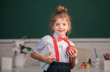 İlkokulda sınıfta okuyan sevimli küçük bir çocuk. Eğitim, öğrenme ve çocuk kavramı. Dahi çocuk, bilgi günü