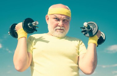Rehabilitasyon merkezinde kıdemli adam egzersiz. Dumbbells kaldırma. Yaşlı yaşlı emekli için sağlık kulübü veya rehabilitasyon merkezi. Spor merkezinde dambıl kaldırma kıdemli spor adam