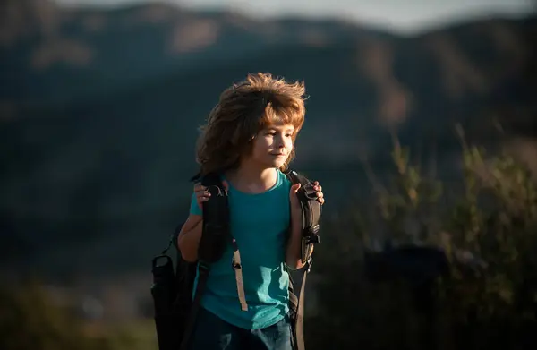 Stock image Kid with backpack hiking in scenic mountains. Boy local tourist goes on a local hike.