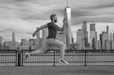 Kaçak. Sokakta koşan bir adam. Olgun koşucu ve spor modelleri New York 'ta Manhattan yakınlarında antrenman yapıyor. Milenyum sporcusu dışarıda spor yaparken koşuyor.