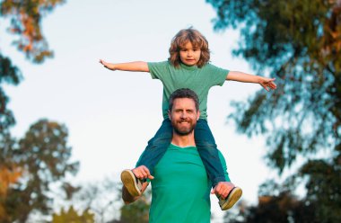 Mutlu babadan oğula. Küçük çocuk babasının omuzlarında