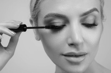 Kirpikleri şekillendiren kadın model. Güzel kirpikli kadın gözü. Fırçayla mükemmel şekilli kirpikleri var. Kirpikleri boya