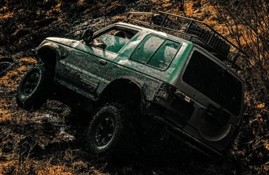 Çamurlu bir tarlada izler. Ülke yol ve dağlar arka plan üzerinde büyük offroad araba tekerleği için alt görünümü. Off-road araç dağa gidiyor. Ralli yarışı