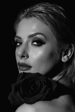 Bright make-up close up face. Valentines day, celebration and beauty concept. Charming romantic young woman with flowers, studio background