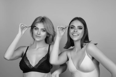 Eyebrow shaping, two woman combs eyebrows with a brus. Eyebrow line. Makeup and cosmetology concept. Female models girlfriends with long eyelashes and thick eyebrows. Perfect shaped brow