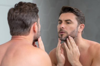 Beyaz tenli güzellik uzmanı sağlıklı cilt için nemlendirici yüz kremi kullanıyor, erkek derisi konsepti. Erkek güzellik ve cilt bakımı portresi. Tıraş olduktan sonra sağlıklı bir yüz, yüz bakımı, cilt bakımı.