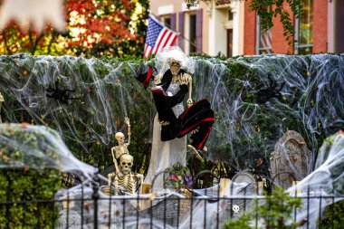 Cadılar Bayramı süslemeleri. Amerikan evi için Cadılar Bayramı balkabağı ve iskeleti. Bir Amerikan evinin ön bahçesinde dekore edilmiş korkunç bir şey. Şeker mi şaka mı? Amerika 'da Cadılar Bayramı. Amerika 'da Cadılar Bayramı