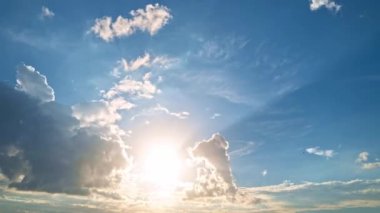 Bulutların üzerinde dramatik bir ışıkla gün batımı. Güneş batıyor, bulutlar mavi ve turuncu dramatik gökyüzünde, güneş ışınlarıyla. Gece Gökyüzü zaman çizelgesi. Gün batımında hareket eden bulutlar. Akşam Bulutları