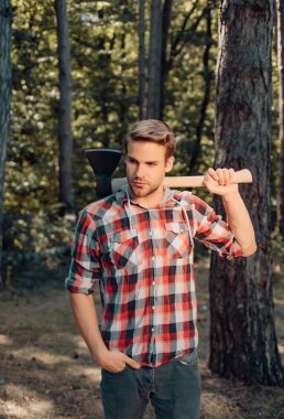 Harvest of timber. Lumberjack worker walking in the forest with axe. Deforestation. Lumberjack in the woods with an ax. Logging. Bearded man with axe concept clipart