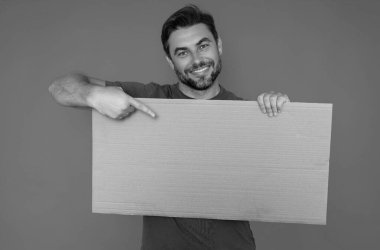 Promosyon gösteren orta yaşlı bir adam. Boş tahta kavramına parmak basmak. Kopyalama uzayı olan boş tabela. Reklam konsepti. Fotokopi alanı olan reklam panosu, boş model. Boş tabela, pano