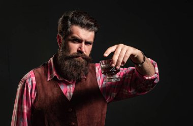 Bardaktan alkol içen adam. Degukasyon ve tatma. Moda tarzı konsept. Barmen bir bardak viski tutuyor.