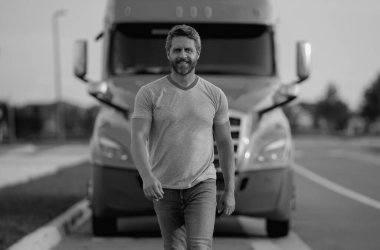 Kamyonun yanında erkek sürücü var. Kamyonun yanında bir kamyon şoförü var. Yakışıklı, orta yaşlı kamyoncu kamyoncu adam. Ulaşım endüstrisi araçları. Kamyonun önündeki yakışıklı adam.