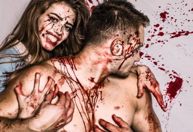 Cadılar Bayramı 'nda yakışıklı bir çift ve uzun saçlı seksi bir kız ve geleneksel sonbahar bayramı sembolü olarak kırmızı kan. Seksi kadın vampir bir erkeğin boynunu ısırıyor.