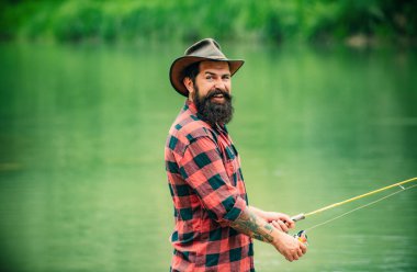 Fisherman man on river or lake with fishing rod