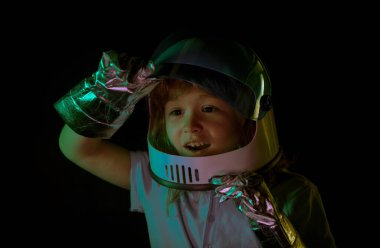 Uzay miğferi ve metal kostümüyle astronot olmaya çalışan hayret verici küçük çocuk. Heyecanlı çocukların yüzünü kapatın.