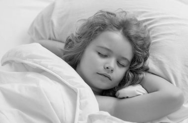 Çocuk tatlı rüyalar görüyor. Çocuk yatakta uyuyor. Yatak odasında rahat bir yatak. Yumuşak yastık, rahat, rahat yatak konsepti. Sağlıklı çocuklar uyuyor.