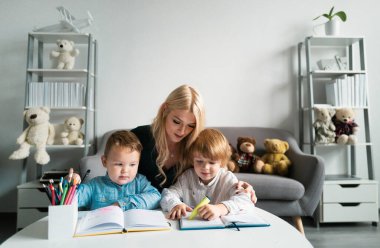 Öğretmen anne yaratıcı çocuklarla çalışıyor. Öğretmen çocukların ders almasına yardım ediyor.