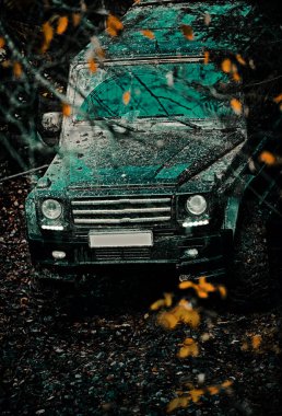 Jeep bir su birikintisine çarptı ve bir toz püskürtüsü aldı. Ralli yarışı. Dağ yolunda off-road yolculuğu
