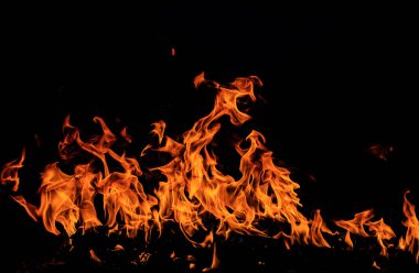 Siyah arka planda yangın alevleri. Ateş, izole edilmiş, soyut bir yapı. Yanan ateşle yanan efekt