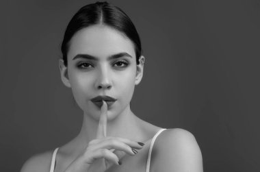 Say secret hush be quiet with finger on lips. Shhh gesture isolated on studio background portrait. Girl showing hush. Woman say secret hush be quiet with finger on lips, shhh gesture