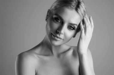 Güzel yüzlü, pürüzsüz ciltli, çıplak omuzlu, şehvetli bir kadın. İzole edilmiş stüdyo arka planında doğal makyajlı ve güzel gözlü seksi bir model. Çıplak omuzlu güzel seksi manken kız.