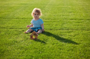 Sigortacı çocuklar. Bebek yeşil çimlerde oynuyor. Parkta bahar mevsimi