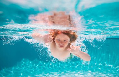 Child boy swim under water in sea. Kid swimming in pool underwater. Happy boy swims in sea underwater, active kid swimming, playing and diving, children water sport. Kids swim on summer vacation