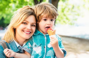 Icream açık havada. Annesi ve çocuğu abur cuburla. Lezzetli yaz dondurması. Yüzünü kapat.