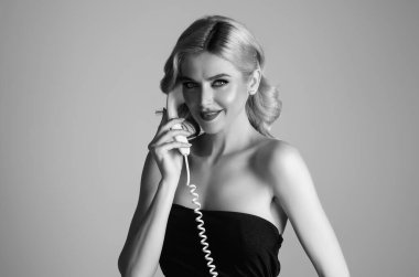 Retro telefondan konuşan seksi kadın. Retro sabit hat telefonu. Sabit telefondan konuşan güzel, şehvetli genç bir kadın. Retro telefondan konuşan seksi kız. Kadın telefonu tut.