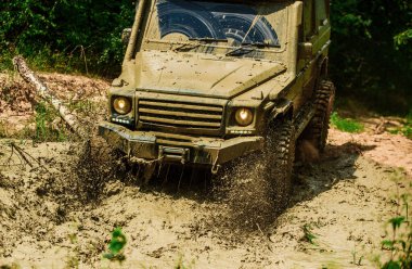 Off-road yarışında çamur ve su sıçraması. En iyi off road araçları. Büyük 4x4 arabalı seyahat konsepti. Çamurda iz sürmek. 4x4 off-road SUV arabası. Offroad vagonu. Safari. Yol macerası. Macera seyahati