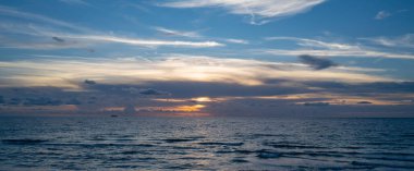 Dramatik gün batımı ve bulutlu gökyüzü. Deniz. Bulutların arasından bulutlu bulutlu bir deniz. Günbatımı okyanusu ve bulutlu gökyüzü arkaplanı. Huzurlu deniz manzarası. Günbatımı deniz suyunun üzerinde bir ufuk. Sakin bulutlu gökyüzü