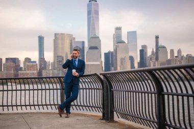 New York 'ta iş. Açık havada akıllı telefon kullanan bir iş adamı. Takım elbiseli bir iş adamı, Manhattan, New York 'taki uygulamalı mesajla cep telefonu kullanıyor. İş konuşmaları. Akıllı telefonlu bir iş adamı.