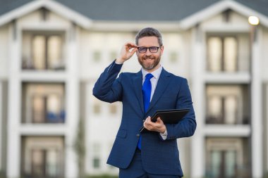 Emlakçı, takım elbiseli bir iş adamı, dışarıda not defteri tutuyor. İspanyol iş adamı. İş adamı komisyoncusu ya da emlakçı. Takım elbiseli bir iş adamı. Emlakçı.