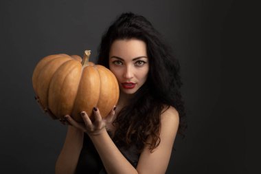 Sonbahar mevsimi. Kadın konsepti. Cadılar Bayramı kadını. Genç kız balkabağını tut. Cadılar Bayramı partisi. Cadılar bayramı balkabağını tutan kadın. Sonbahar ve Cadılar Bayramı konsepti