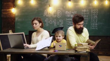 Baba ve anne sevgili oğluna resim çizmeyi ve resim yapmayı öğretiyor. Oyun odasında kitap okuyan küçük çocuklu bir aile. Mutlu, zeki çocuk. Çocuk arka planda yazı tahtasıyla cevap vermeye hazır