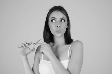 Stüdyo arka planında izole edilmiş makasla saç kesen güzel kadın. Güzel kız saç kesmek üzere. Saç kesimi makas konsepti. Kuaför makası saç stilini değiştirir. Saç modeli makas tut