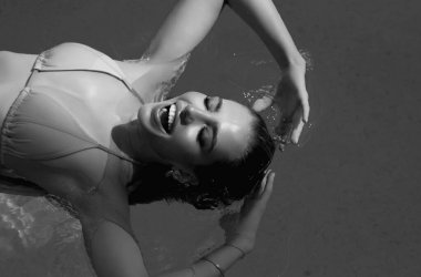 Mayolu seksi kadın havuzda dinleniyor. Suyun içinde bikinili seksi kız portresi. Yüzme havuzunda rahat bir kız. Havuz başında seksi bir manken. Hayatın tadını çıkar, yaz tatilleri, güneşlenme ve seyahatler.
