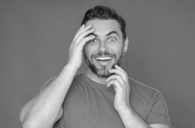 Duygusal olarak korkmuş bir adam korkmuş bir ifadeyle sinirli bir şekilde fobisini gösterir. İnsan tepkisi ve duyguları. Tüh. Dehşete kapılmış üzgün adamın yüz ifadesi parmaklarını ısırır.