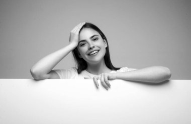 Woman pointing finger on blank board. Woman standing behind the white blank banner or empty copy space advertisement board