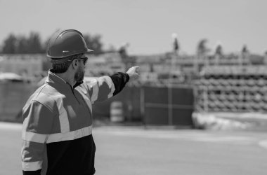 İnşaat işçisi inşaat halinde. Erkek inşaatçı inşaat alanında çalışıyor. Amerikan inşaat sahasında miğferli mühendis portresi.