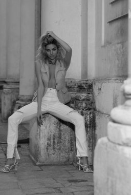 Beautiful sensual young woman posing on street. Fashion and beauty. Sensual girl with sexy body. Street vogue style