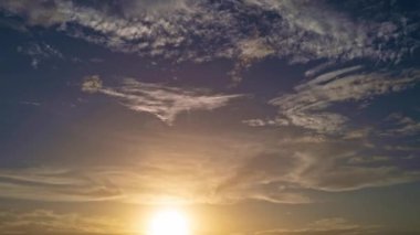 Güneş batıyor, bulutlar mavi ve turuncu dramatik gökyüzünde, güneş ışınlarıyla. Gece Gökyüzü zaman çizelgesi. Gün batımında hareket eden bulutlar. Akşam bulutları. Alacakaranlık gökyüzü zaman aşımına uğradı. Dramatik destansı akşam gökyüzü
