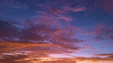 Güneş batıyor, bulutlar mavi ve turuncu dramatik gökyüzünde, güneş ışınlarıyla. Gece Günbatımı Gökyüzü zaman ayarlı. Gün batımında hareket eden bulutlar. Akşam bulutları. Alacakaranlık alacakaranlık gökyüzü zaman aşımı. Dramatik gökyüzü