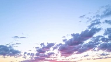 Gökyüzü zaman atlaması. Gün batımında hareket eden bulutlar. Bulutlar akşam boyunca yüzer. Alacakaranlık gökyüzü zaman aşımına uğradı. Dramatik gökyüzü hareket ediyor. Kümülüs ve sirrus fırtınada. Gün doğumu bulutu