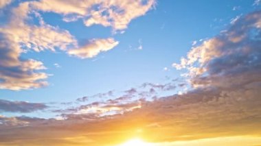 Güneş batıyor, bulutlar mavi ve turuncu dramatik gökyüzünde, güneş ışınlarıyla. Gece Günbatımı Gökyüzü zaman ayarlı. Gün batımında hareket eden bulutlar. Akşam bulutları. Alacakaranlık alacakaranlık gökyüzü zaman aşımı. Dramatik gökyüzü